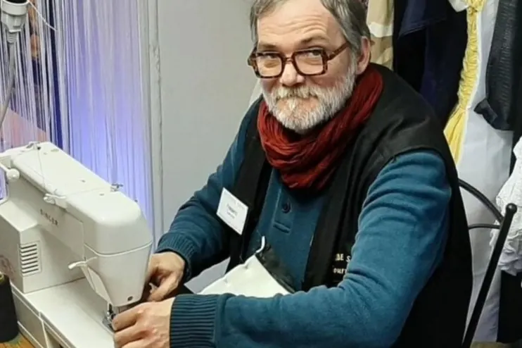 Couturier au travail sur une machine à coudre dans l'atelier de retouches du magasin