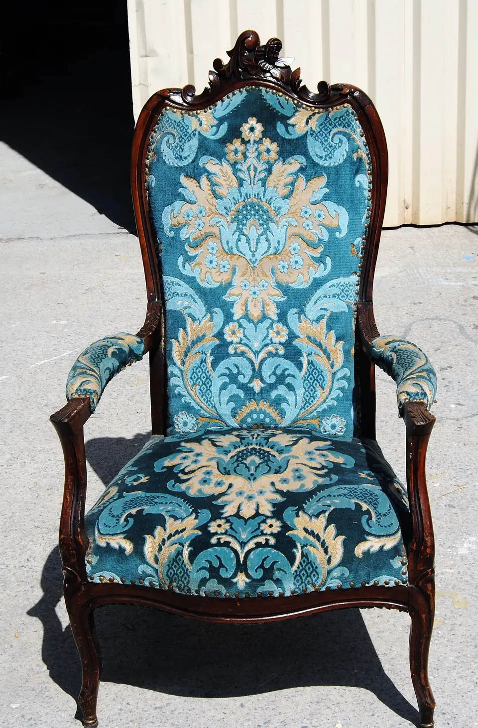 Fauteuil Voltaire en bois sombre, tissu à motif baroque bleu et or